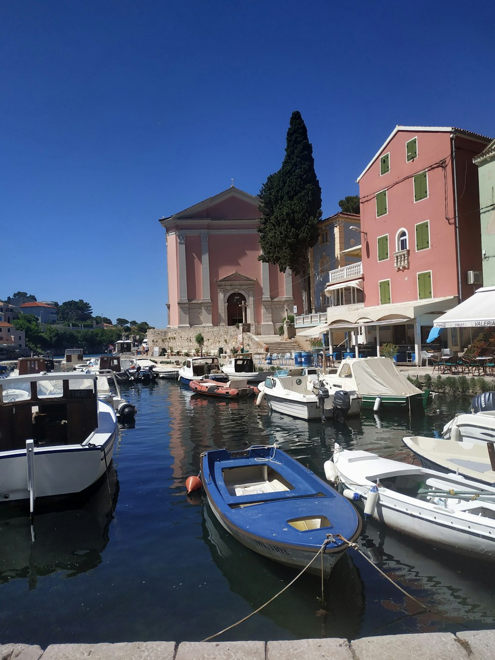 boats on dock near buildings during daytime