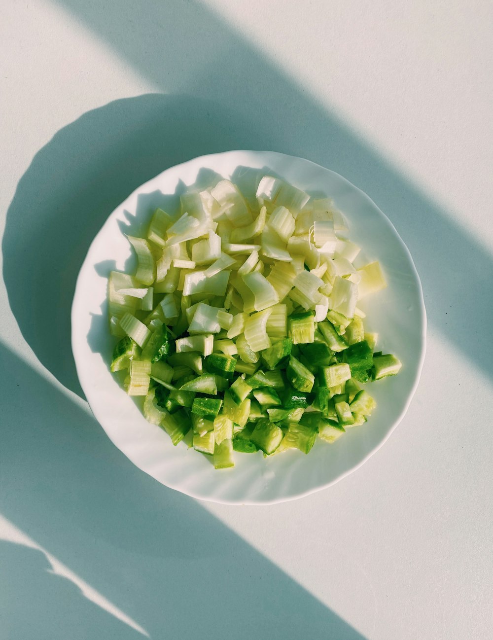 Verdura verde sobre plato de cerámica blanca