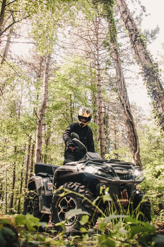 man riding on black motorcycle in forest during daytime in Zagreb Croatia