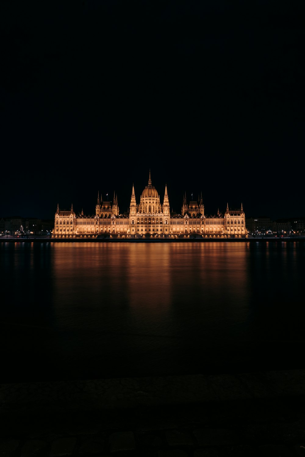 lighted building near body of water during night time