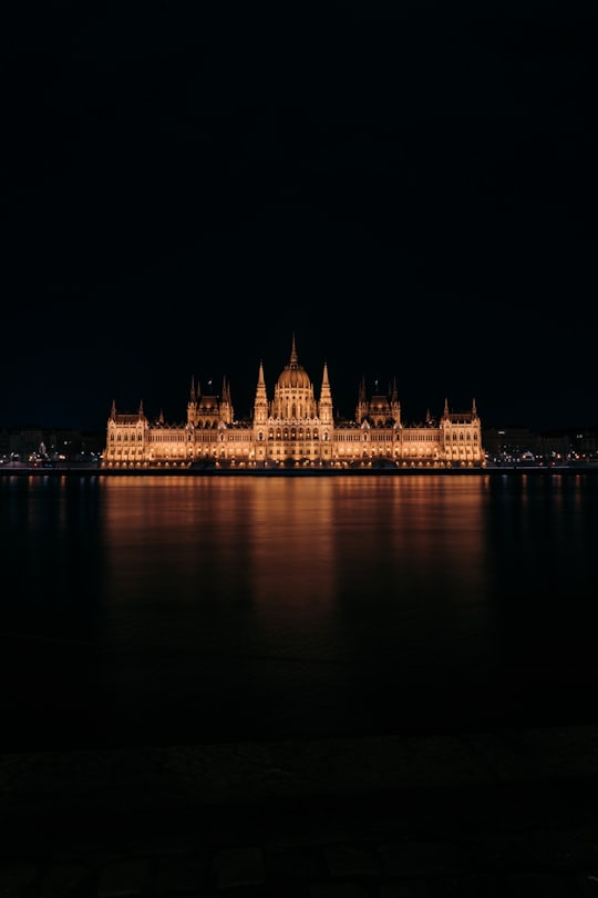 lighted building near body of water during night time in Palace Of Parliament Hungary Hungary