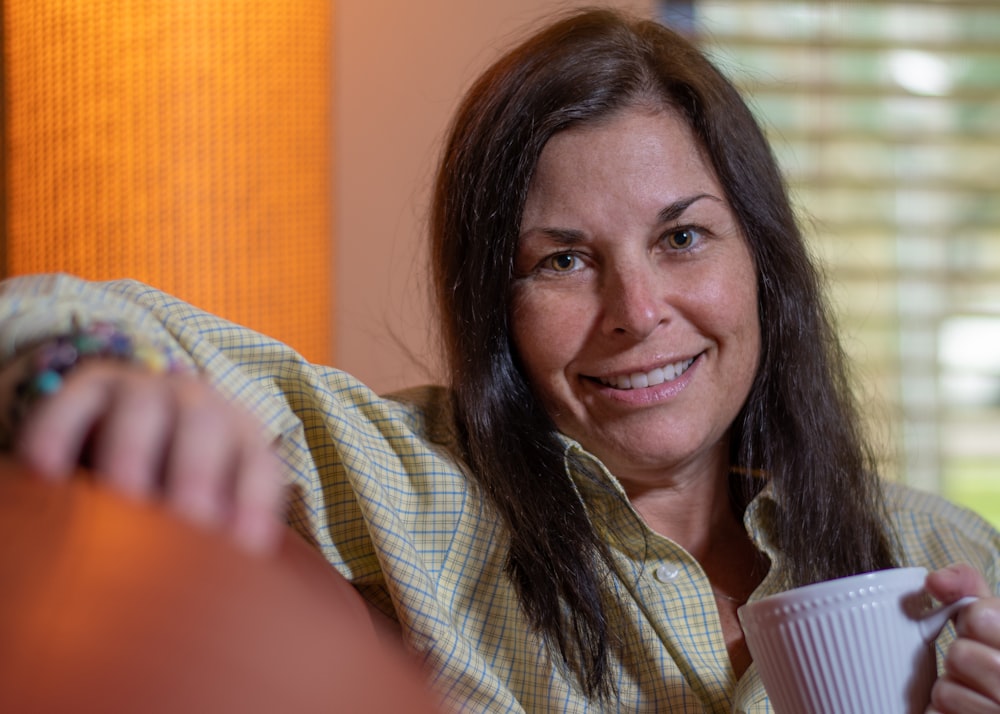 woman in white and black plaid button up shirt smiling