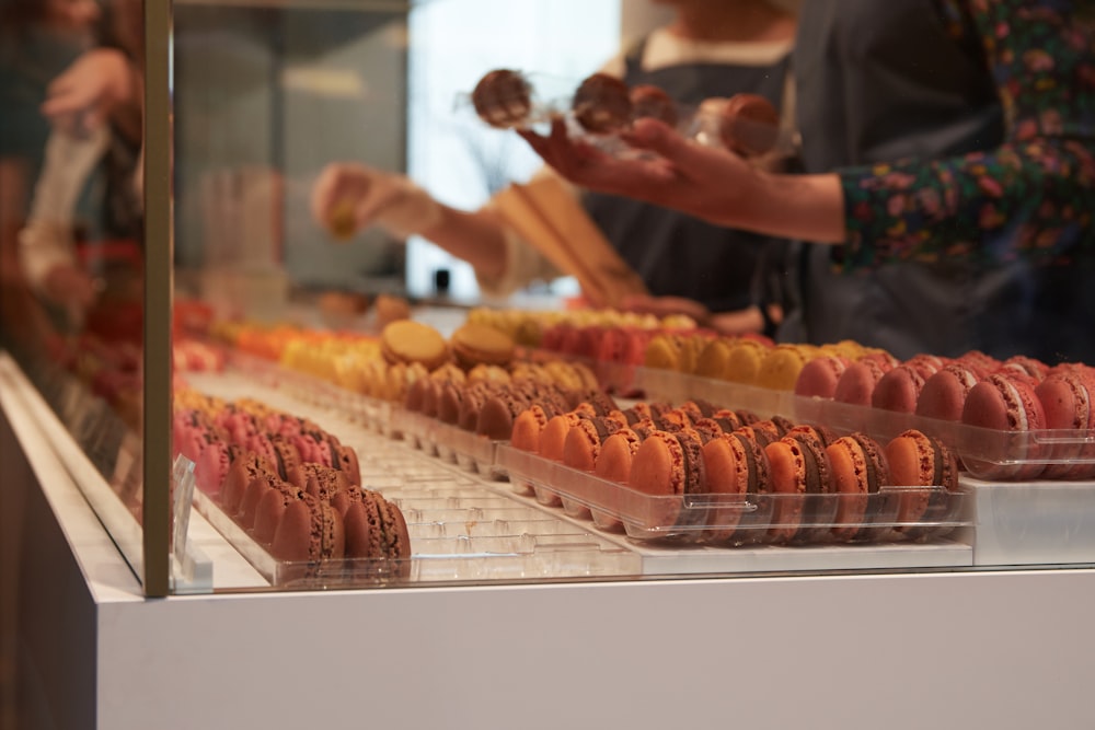 man in white crew neck t-shirt standing in front of food display counter