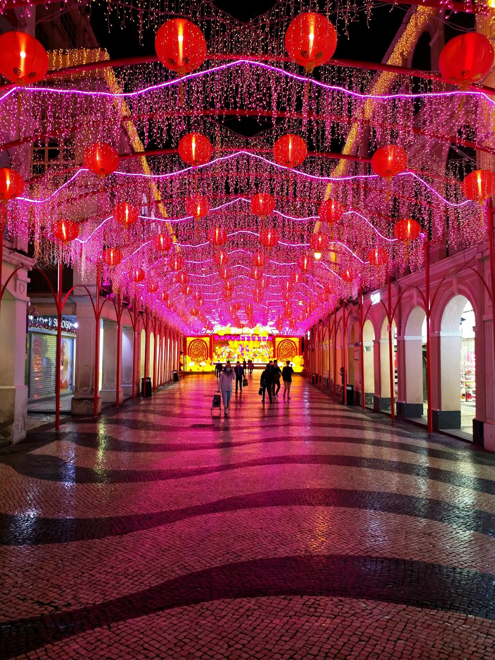 people walking on hallway with red and yellow lights