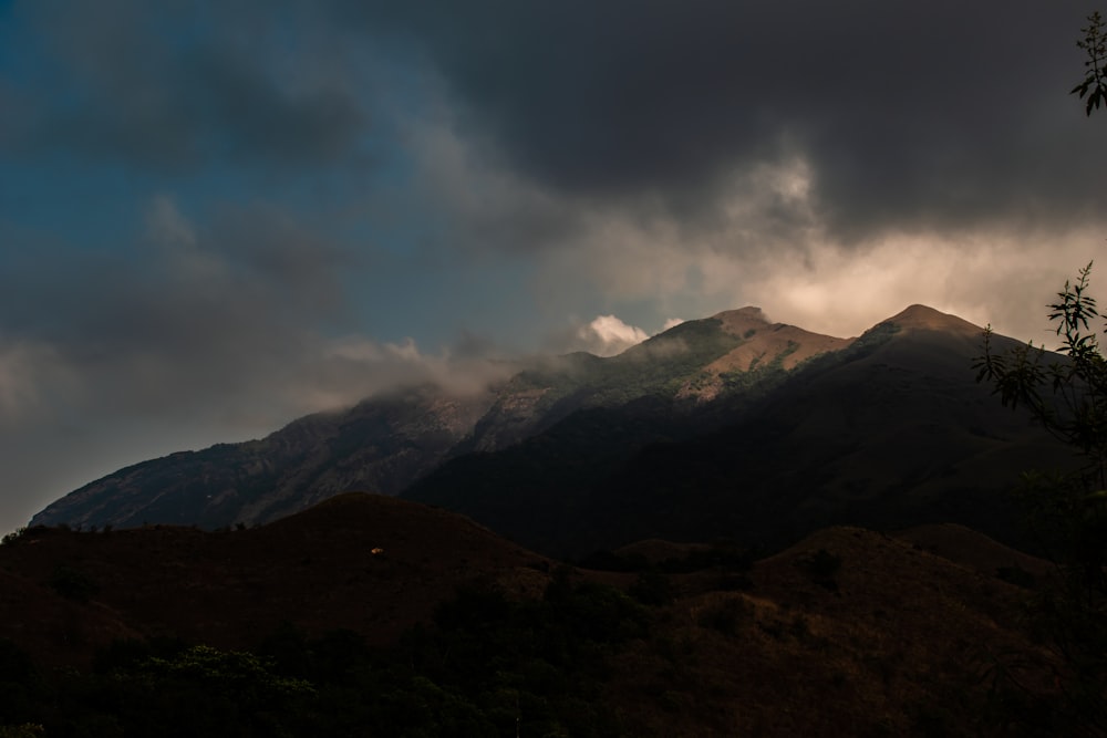 brown and green mountains under white clouds