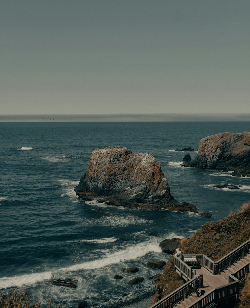 brown and green rock formation on sea during daytime