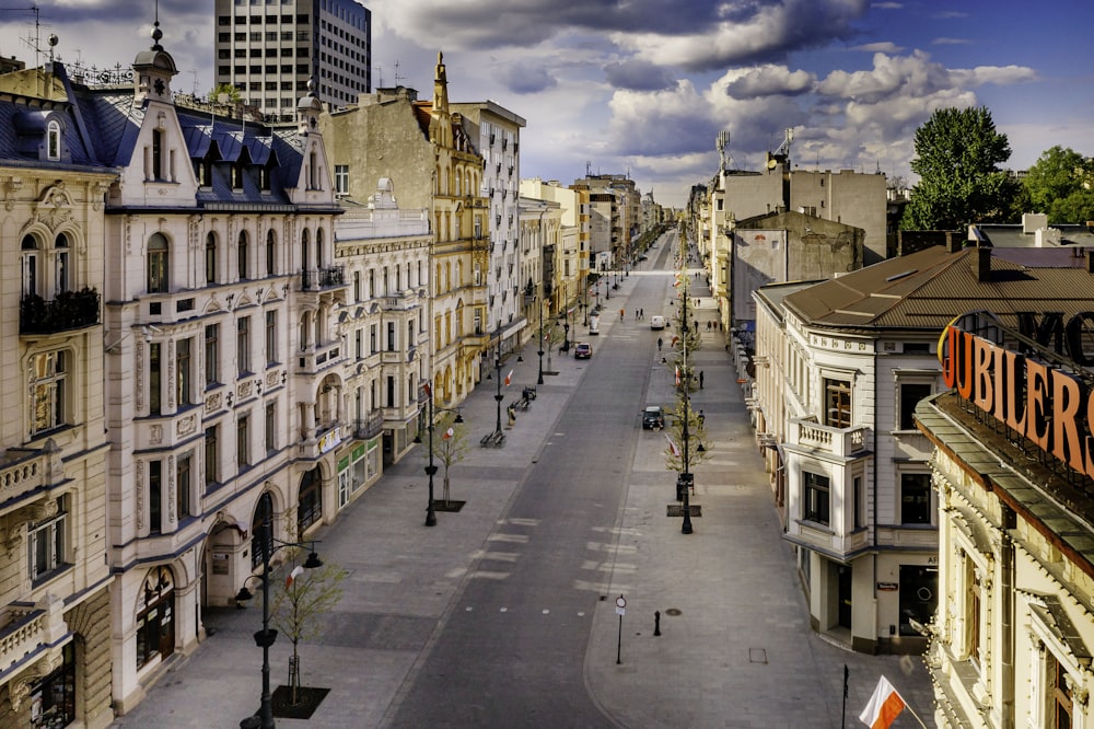 a city street lined with tall buildings under a cloudy sky