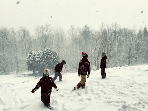 Children bundled in colorful winter jackets playing outside on a snowy day.
