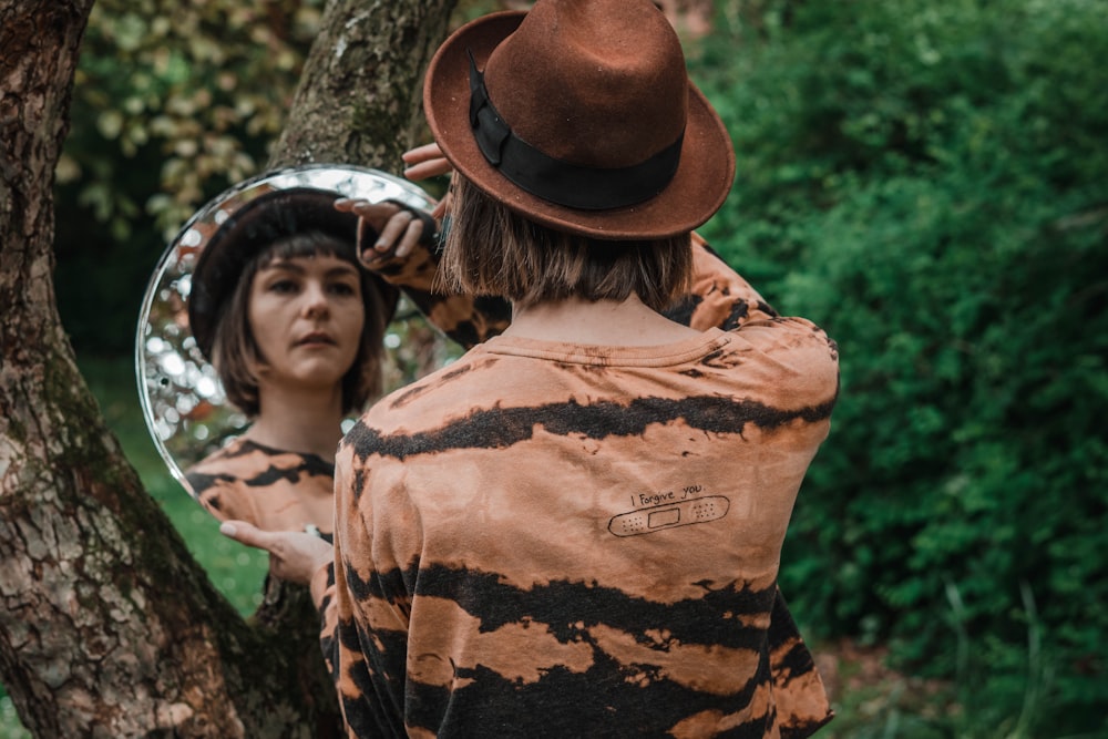 woman in brown hat and orange shirt