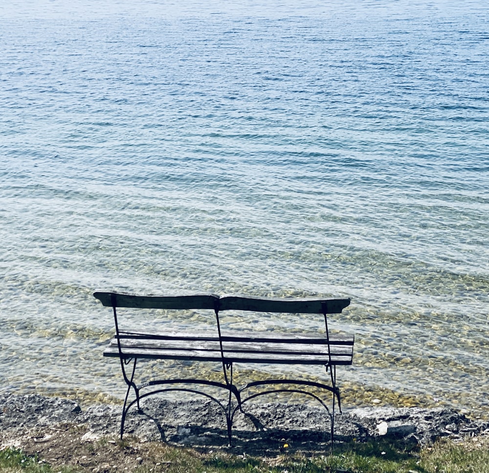 brown wooden bench on seashore during daytime
