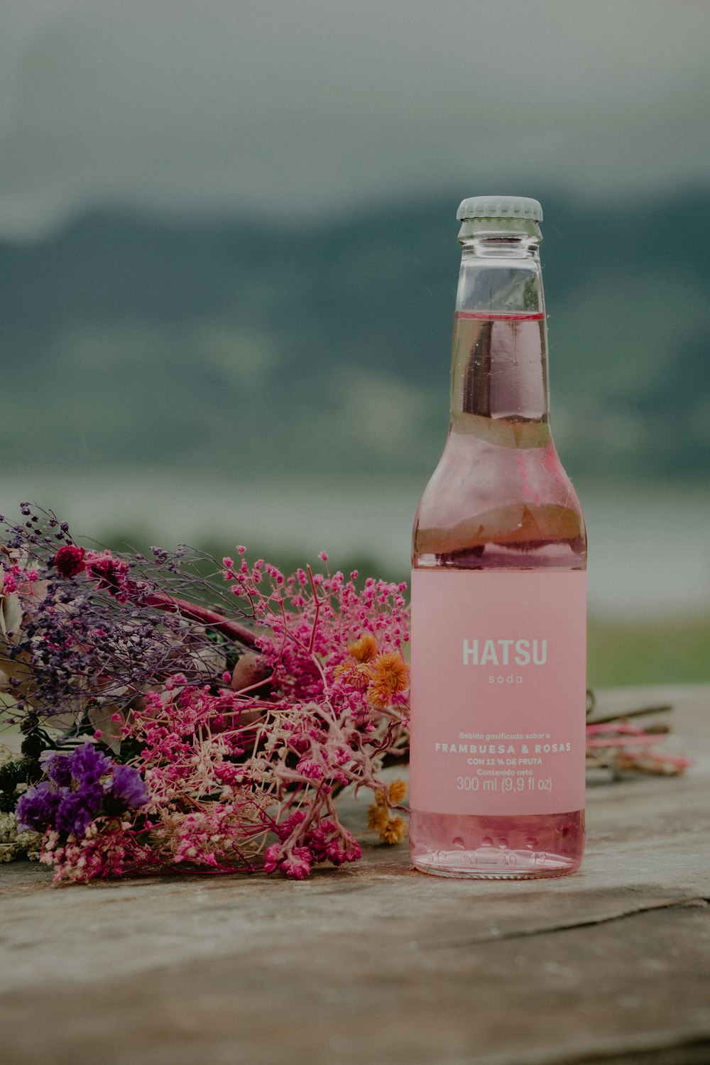 Una botella con una flor roja