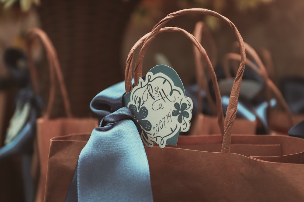 blue and white ribbon on brown leather tote bag