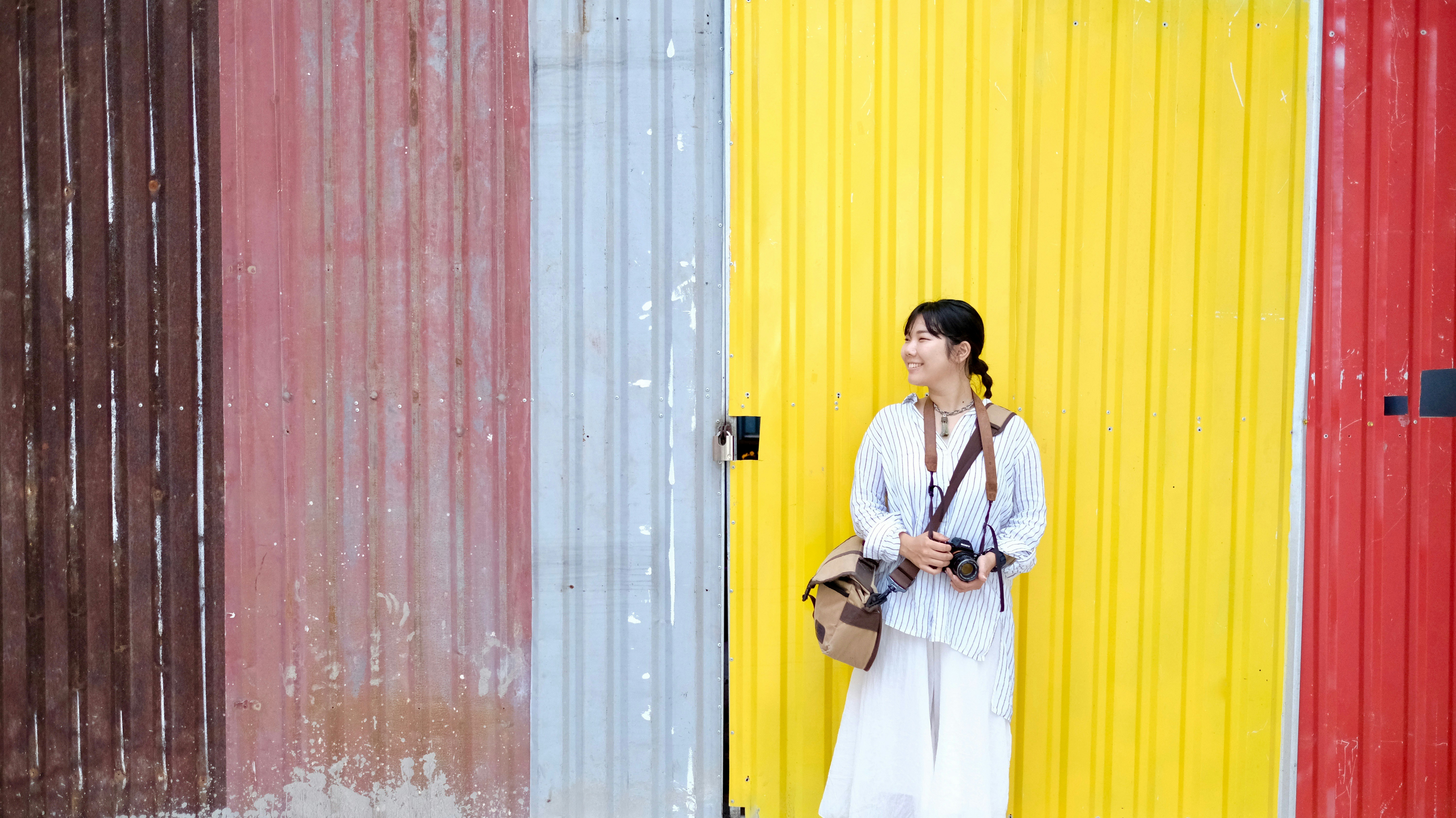 man in white dress shirt standing beside white and brown wall