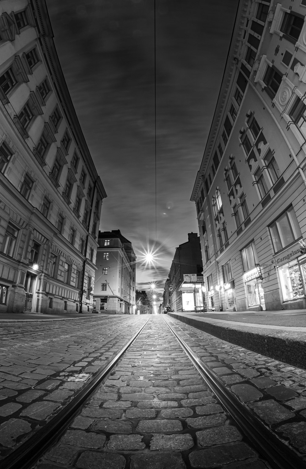 grayscale photo of a street in the middle of a city