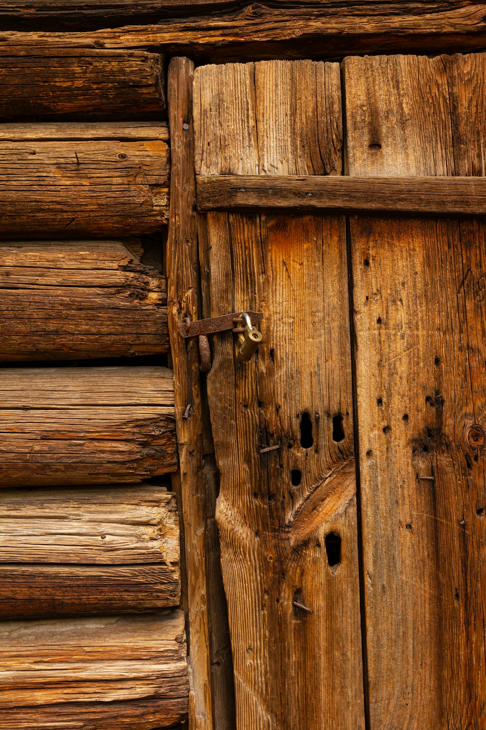 braune Holztür mit Vorhängeschloss