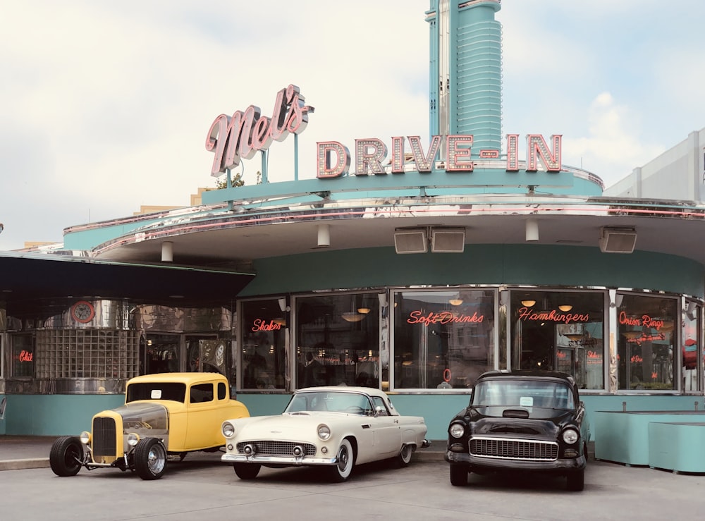 yellow and white vintage car in front of UNKs store