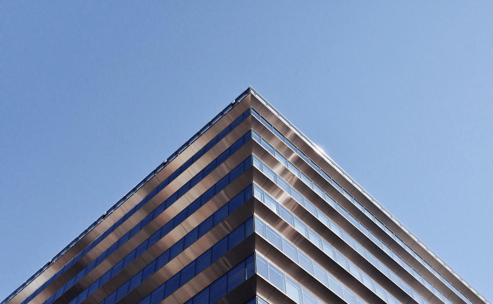 Edificio de hormigón blanco y marrón bajo el cielo azul durante el día