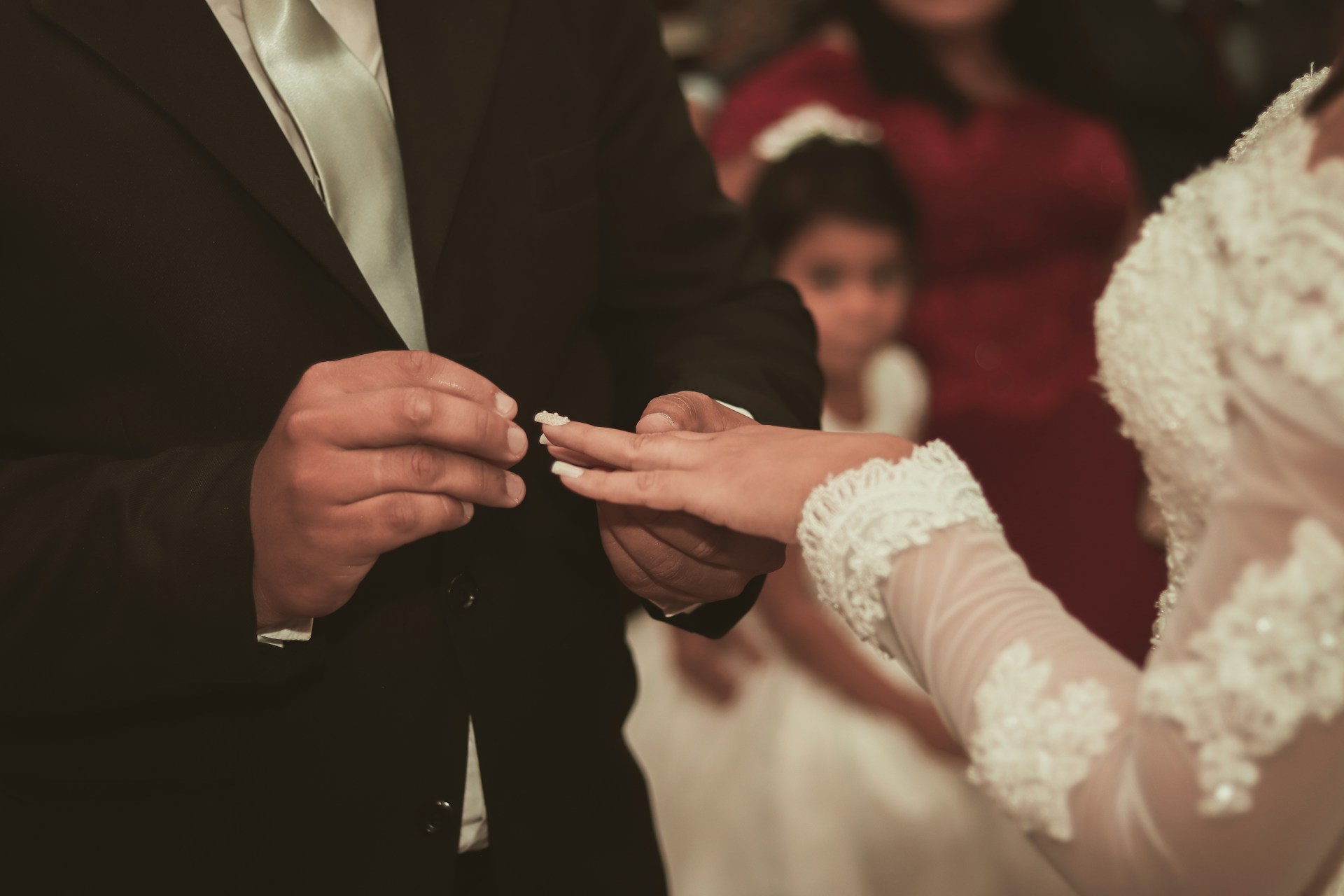 man in black suit jacket holding womans hand
