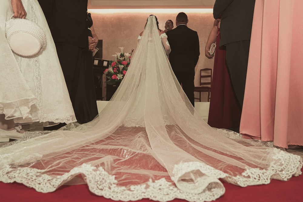 woman in white wedding gown standing beside man in black suit