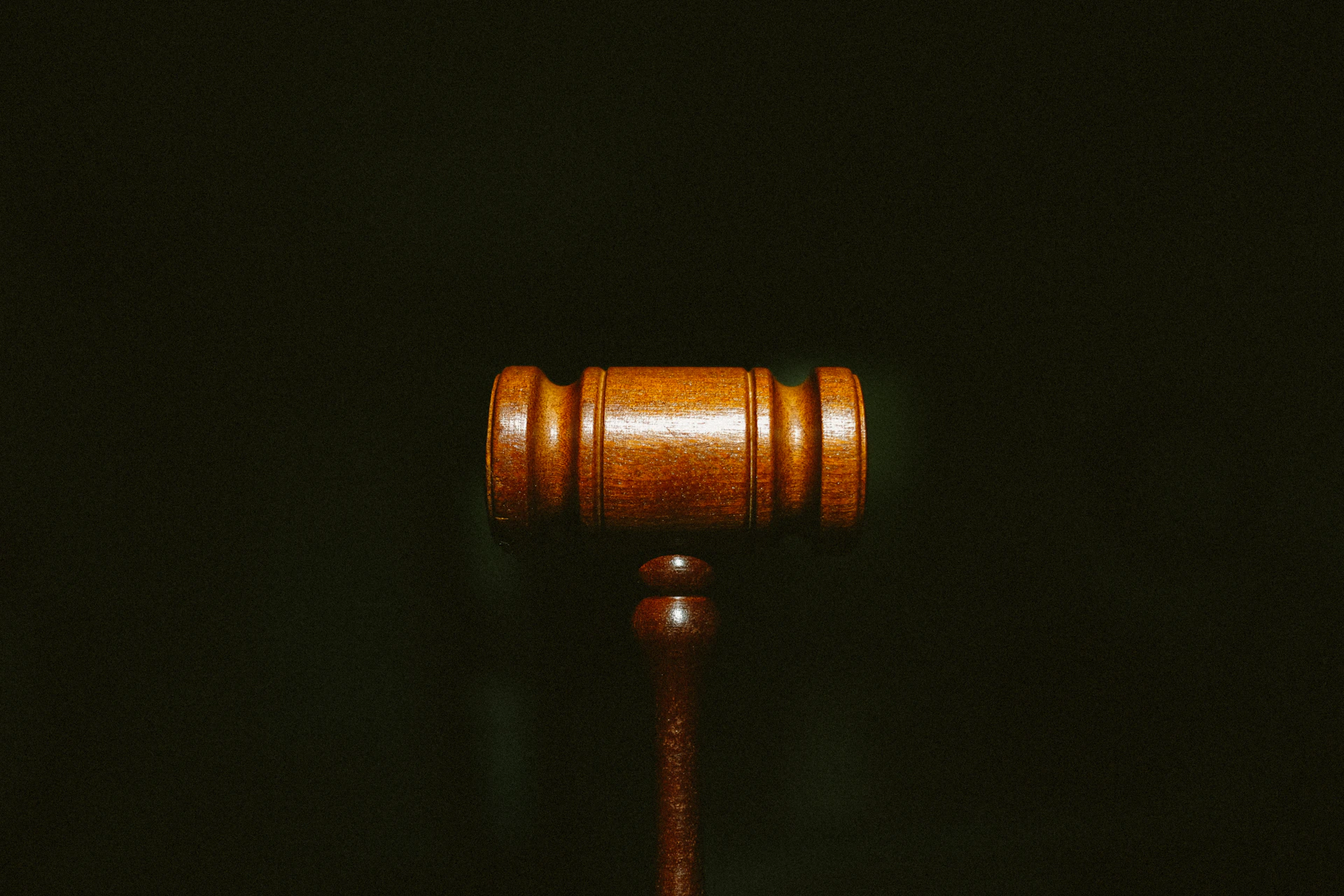 Wooden judge’s gavel against a dark background