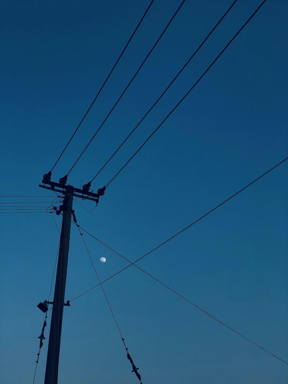 black electric post under blue sky during daytime