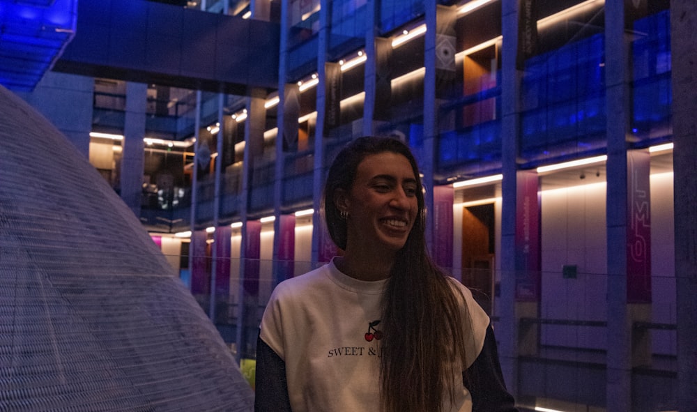 woman in white crew neck t-shirt standing near glass wall