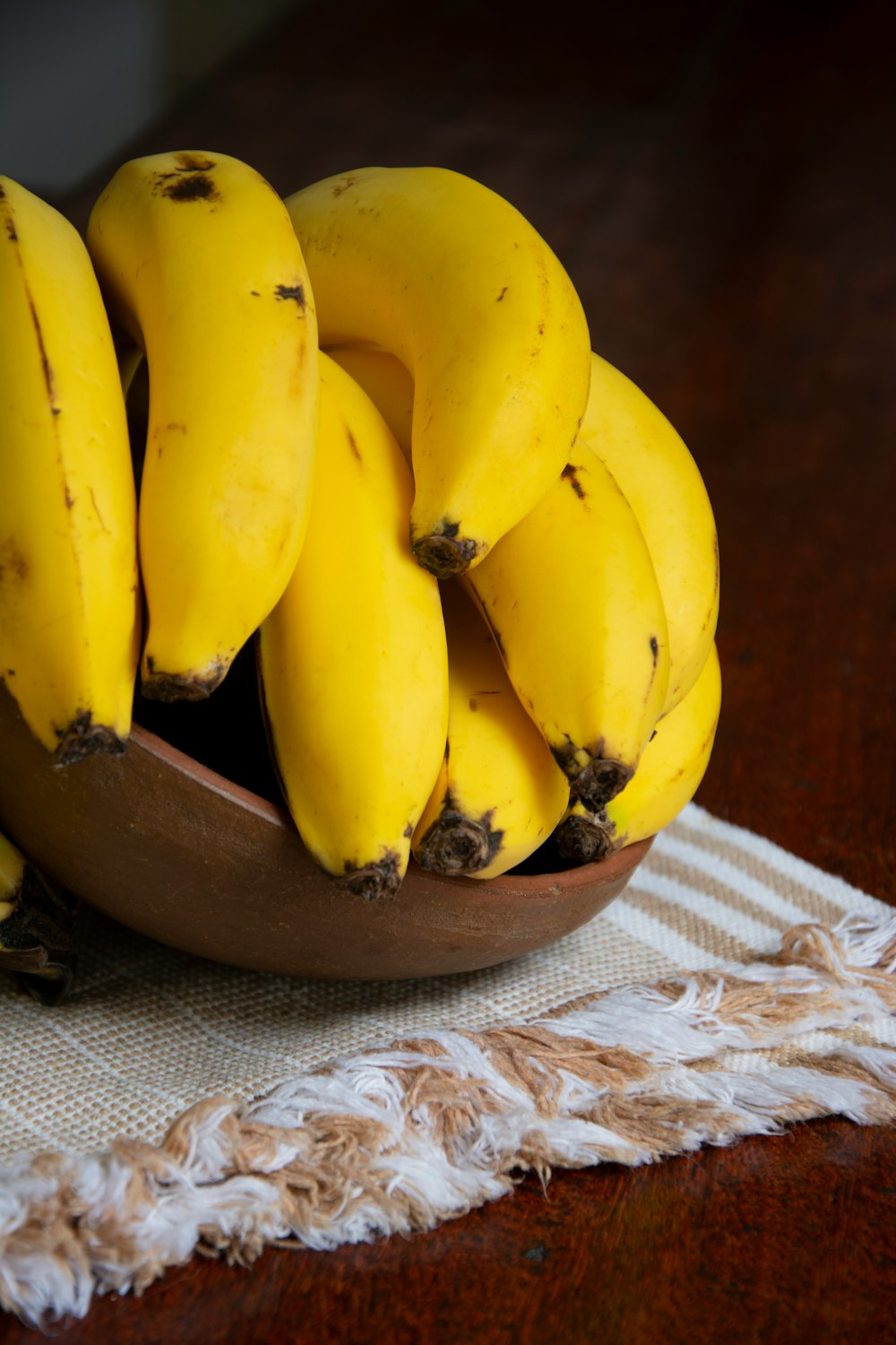 yellow banana fruit on brown wooden bowl