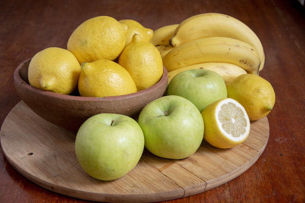 yellow bananas and green apples on brown wooden tray