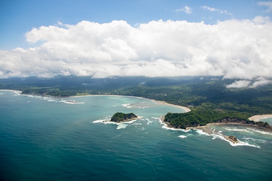 green island in the middle of ocean under white clouds and blue sky during daytime in Guanacaste Province Costa Rica