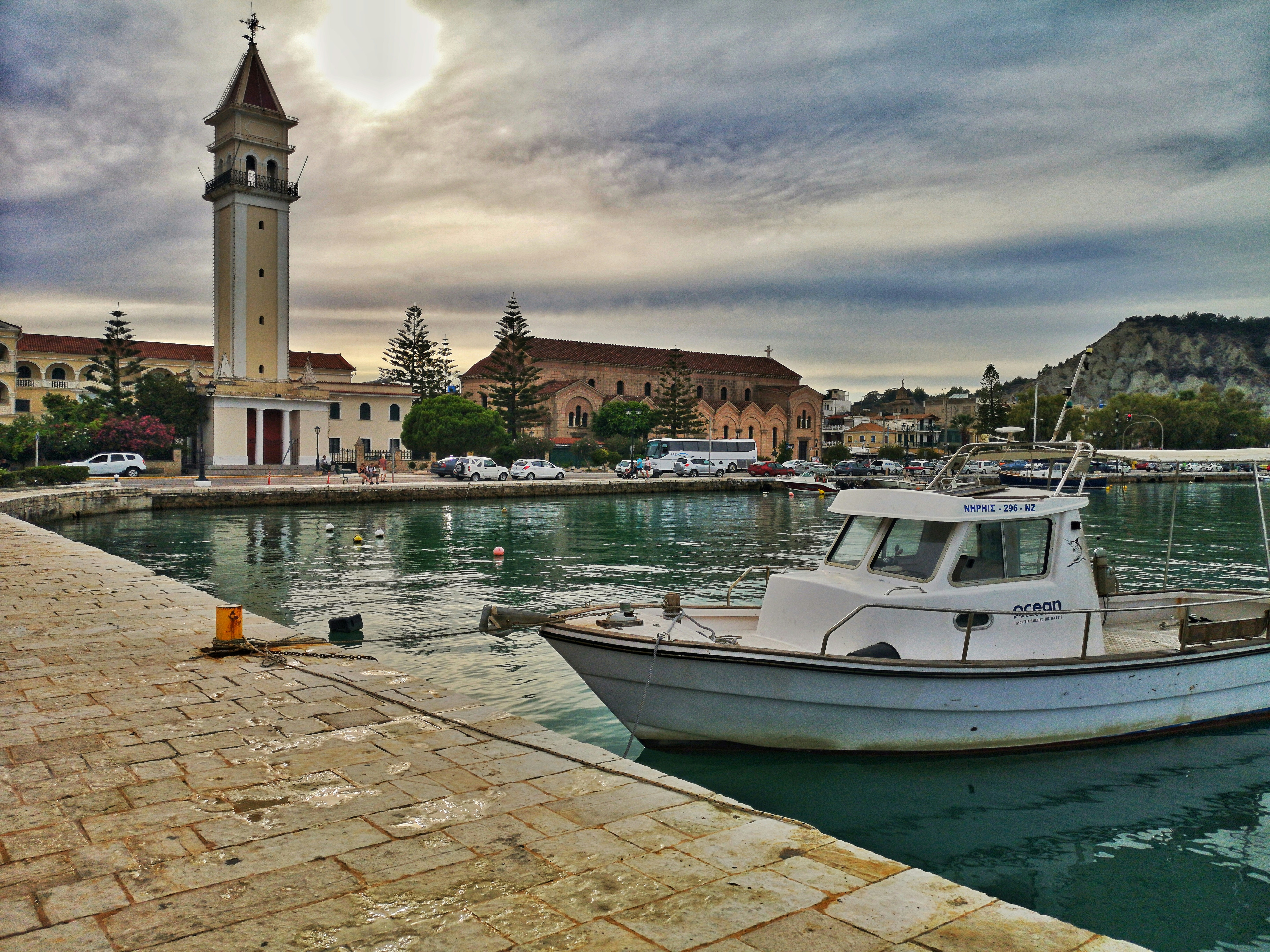 white boat on dock near brown concrete building during daytime