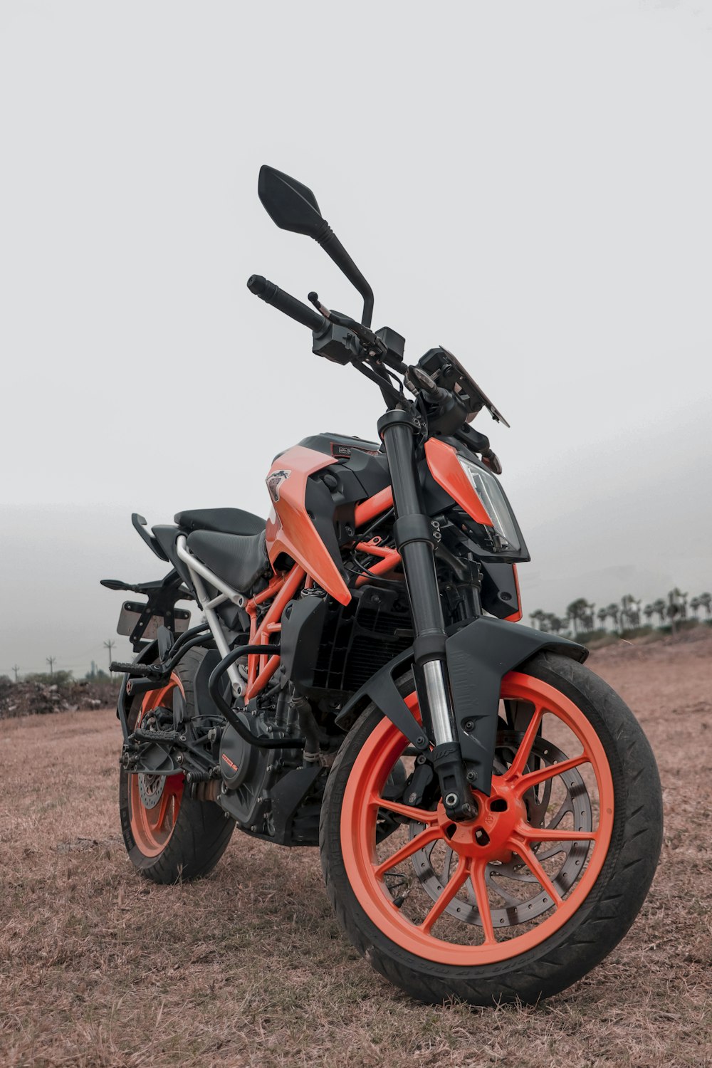 black and orange motorcycle on brown field during daytime