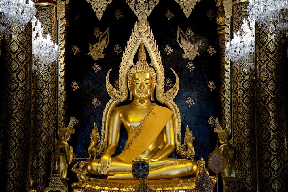 Statuetta di divinità indù in oro su tessuto floreale nero e oro