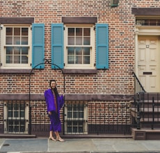 woman in purple long sleeve dress walking on sidewalk during daytime