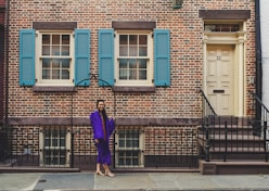 woman in purple long sleeve dress walking on sidewalk during daytime