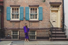 woman in purple long sleeve dress walking on sidewalk during daytime