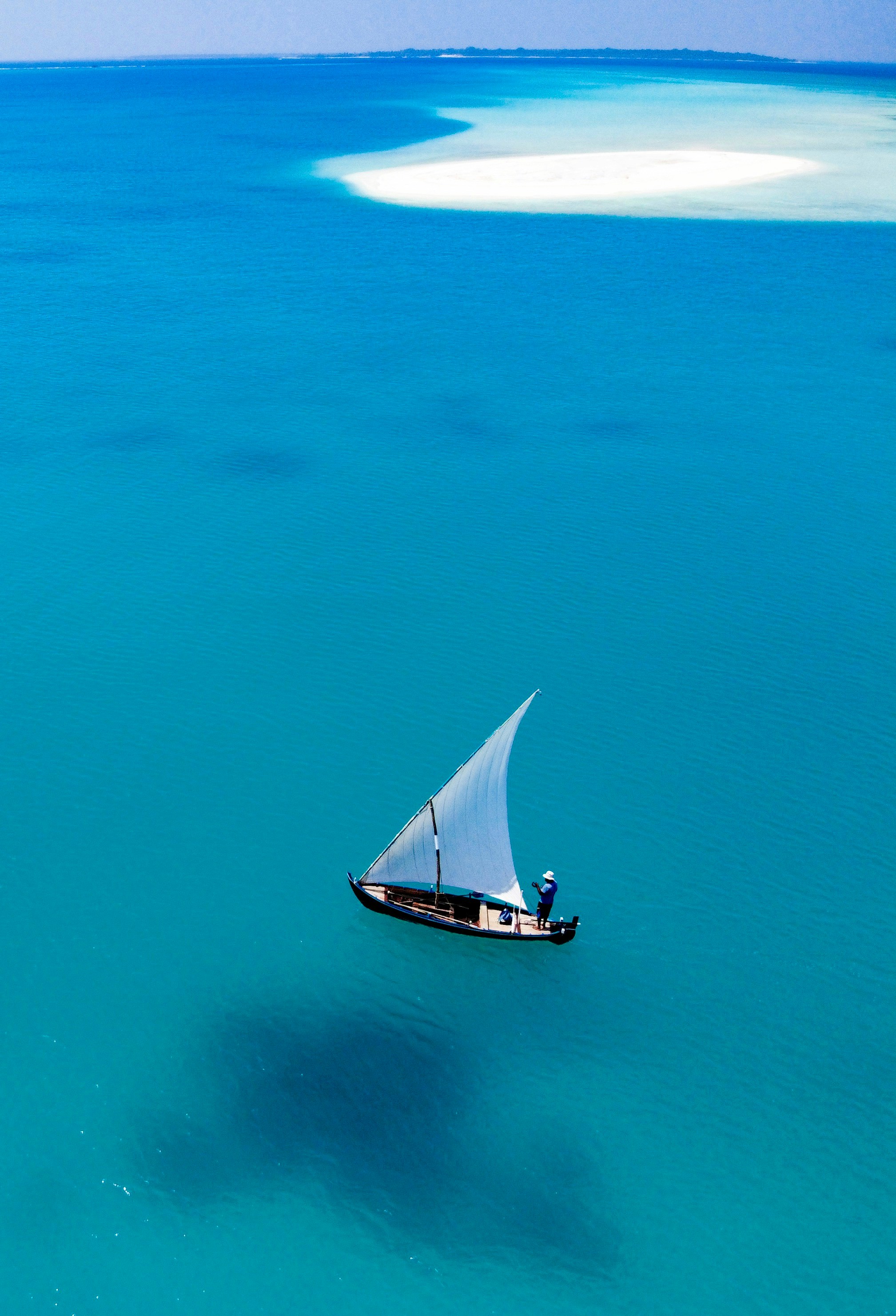 Perahu layar putih dan hitam di laut biru