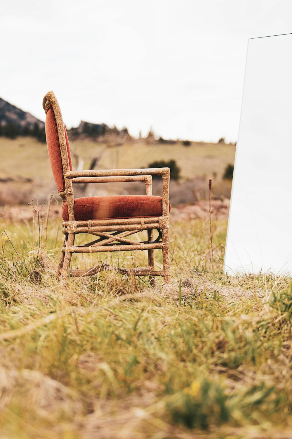 brown wooden armchair on green grass field during daytime