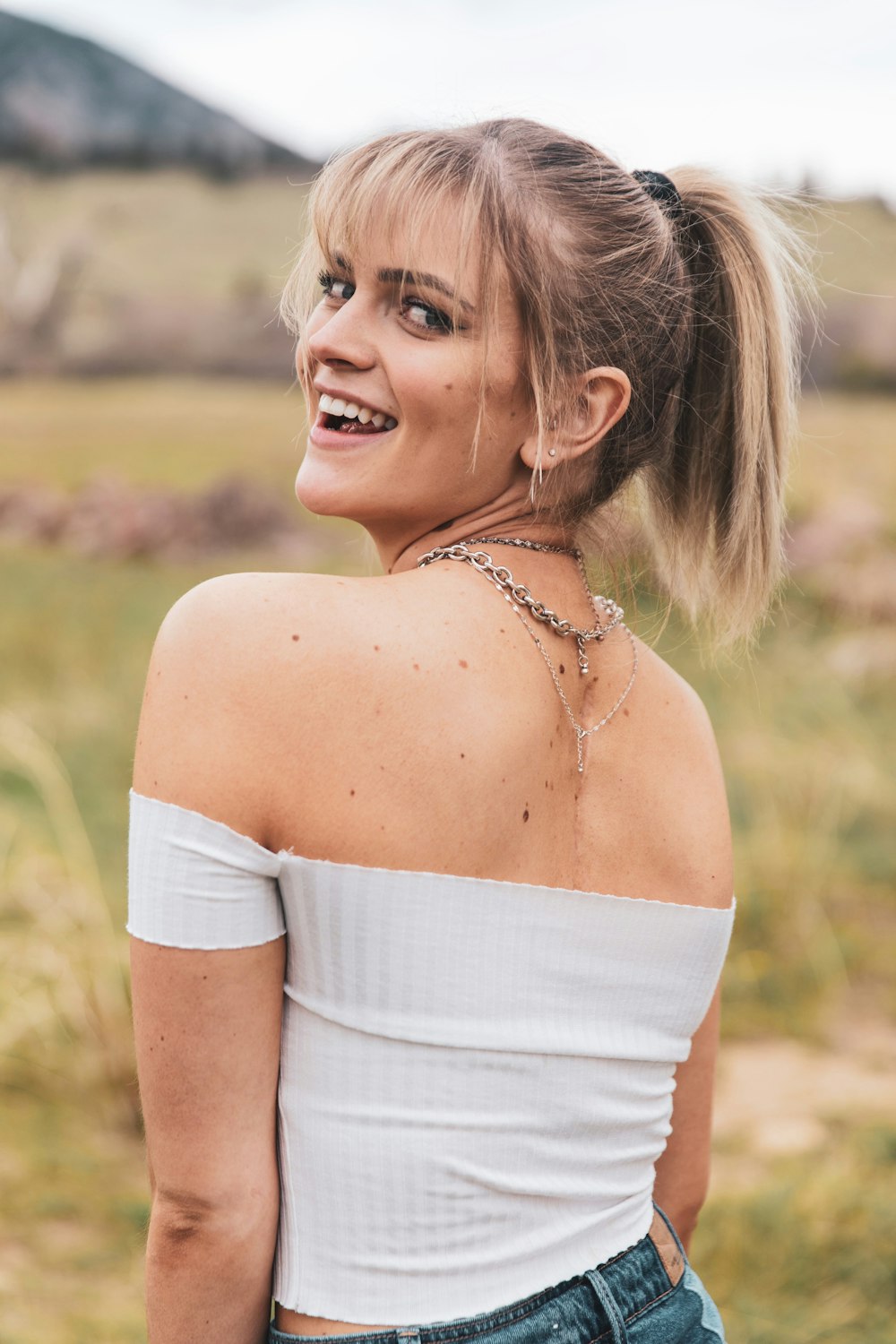 woman in white off shoulder dress smiling