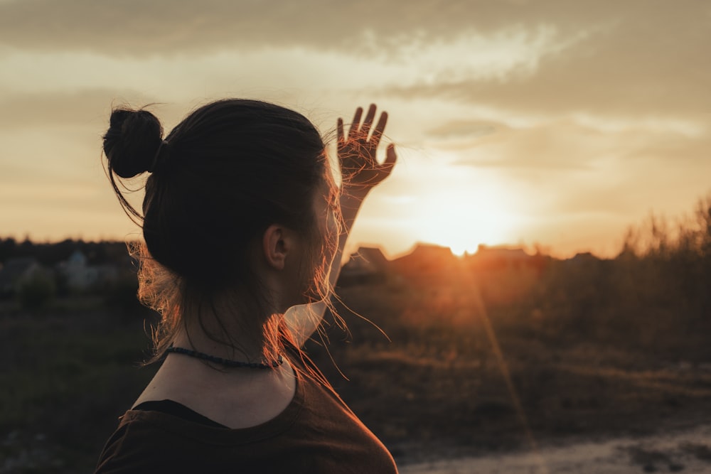 woman in black shirt raising her hands