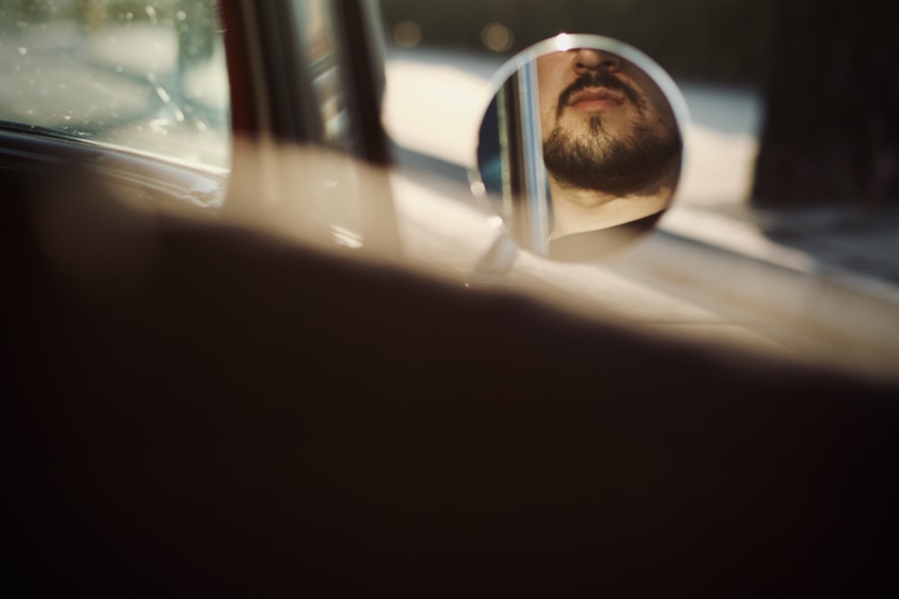 man in black sunglasses looking at the car window during daytime