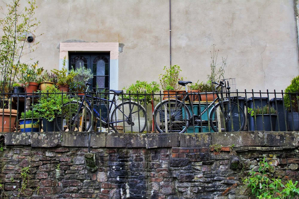 black bicycle parked beside brown concrete wall during daytime