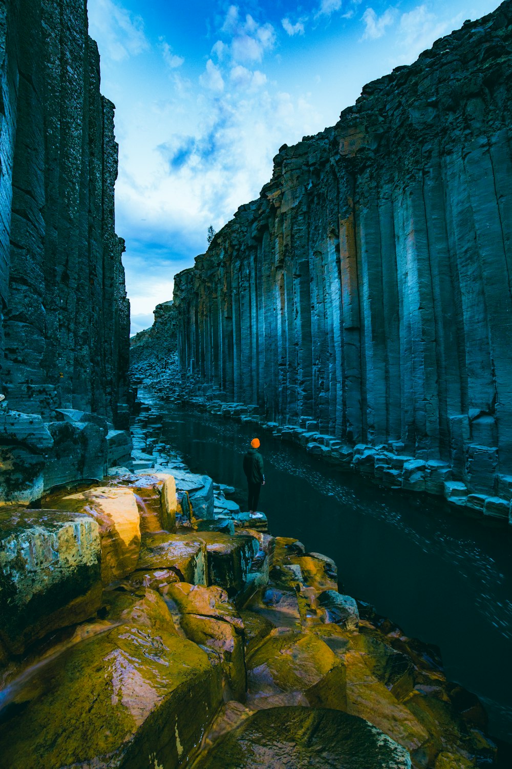 people walking on pathway between gray concrete walls