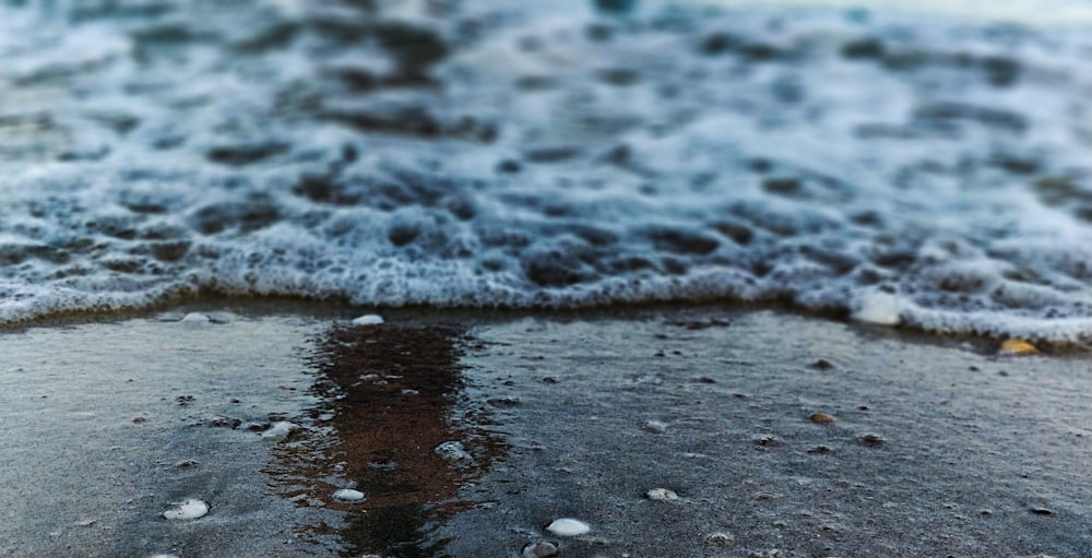 water waves on gray sand during daytime