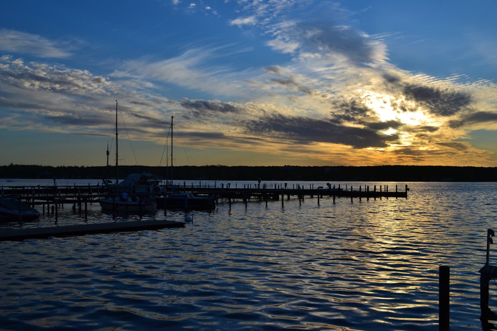 white boat on dock during sunset