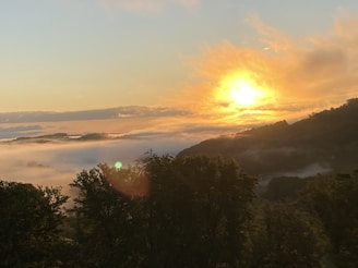 A serene landscape with a sunrise illuminating a peaceful valley.