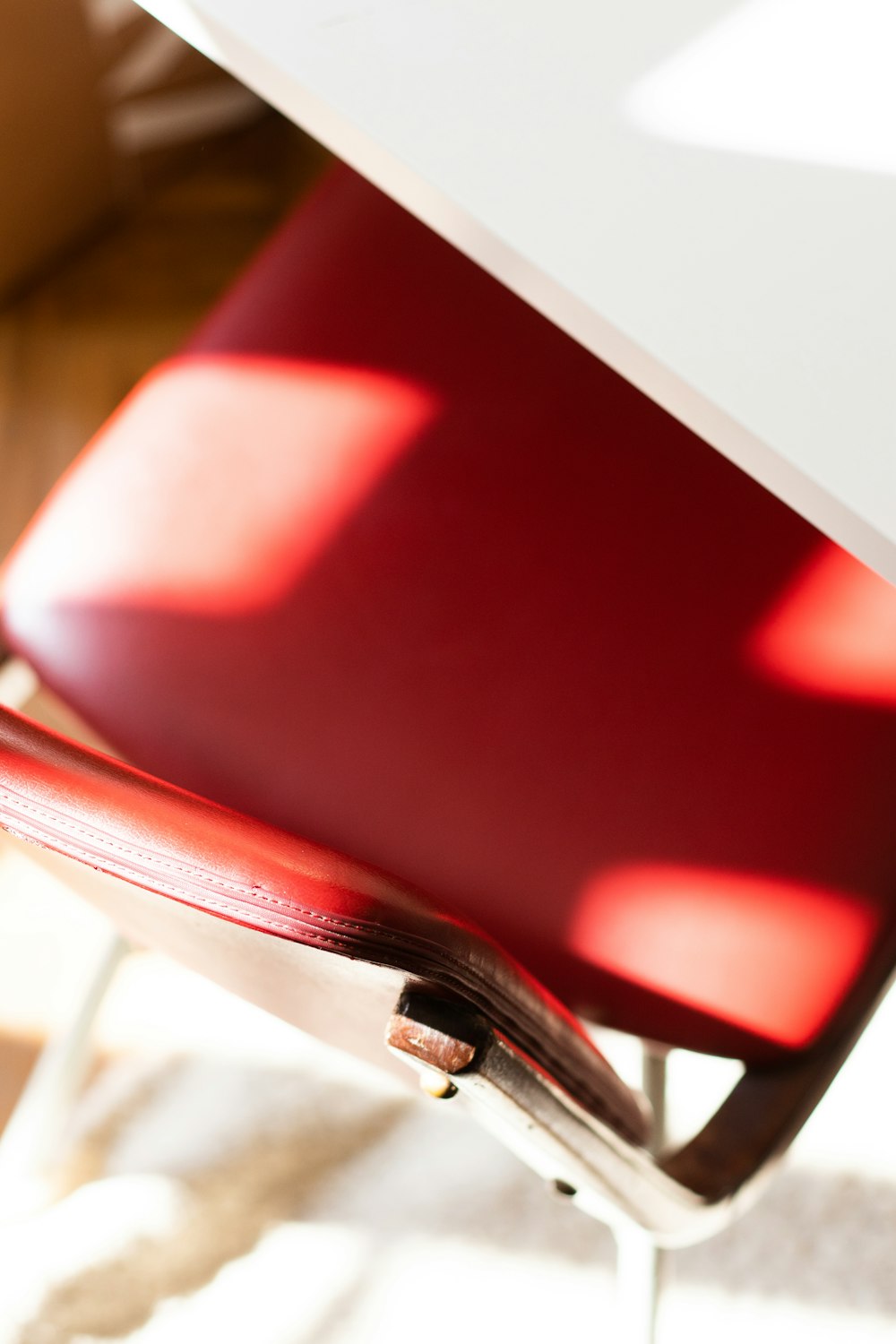 red and silver chair beside white table