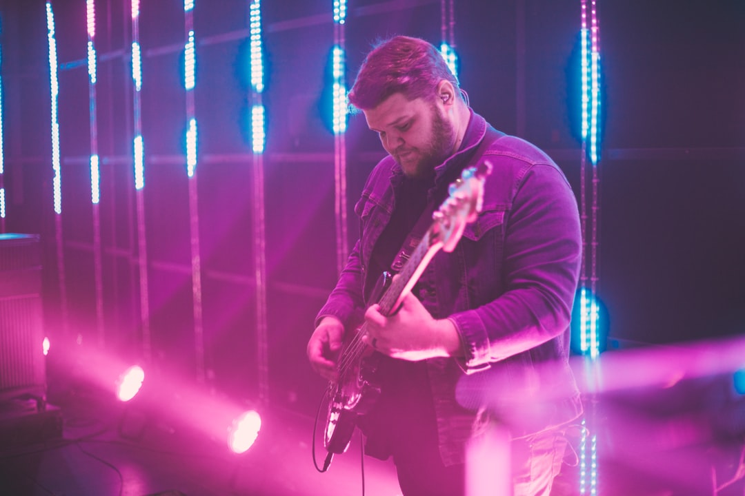 man in black long sleeve shirt playing guitar