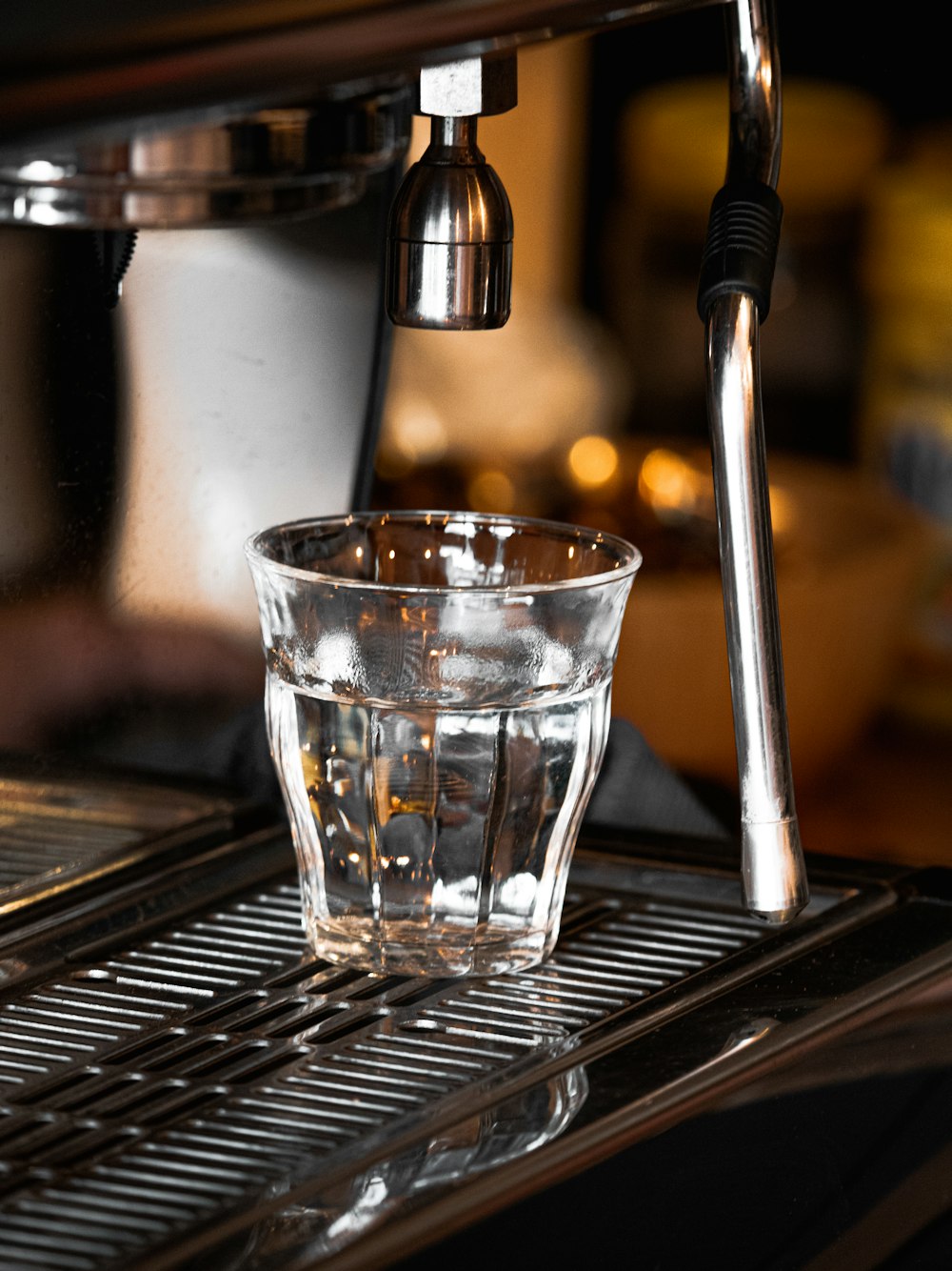 clear drinking glass on silver and black coffee maker