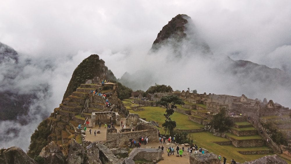 people walking on road near houses and mountain during daytime