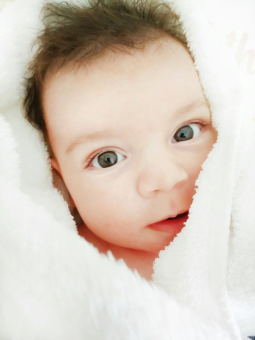 baby covered with white blanket